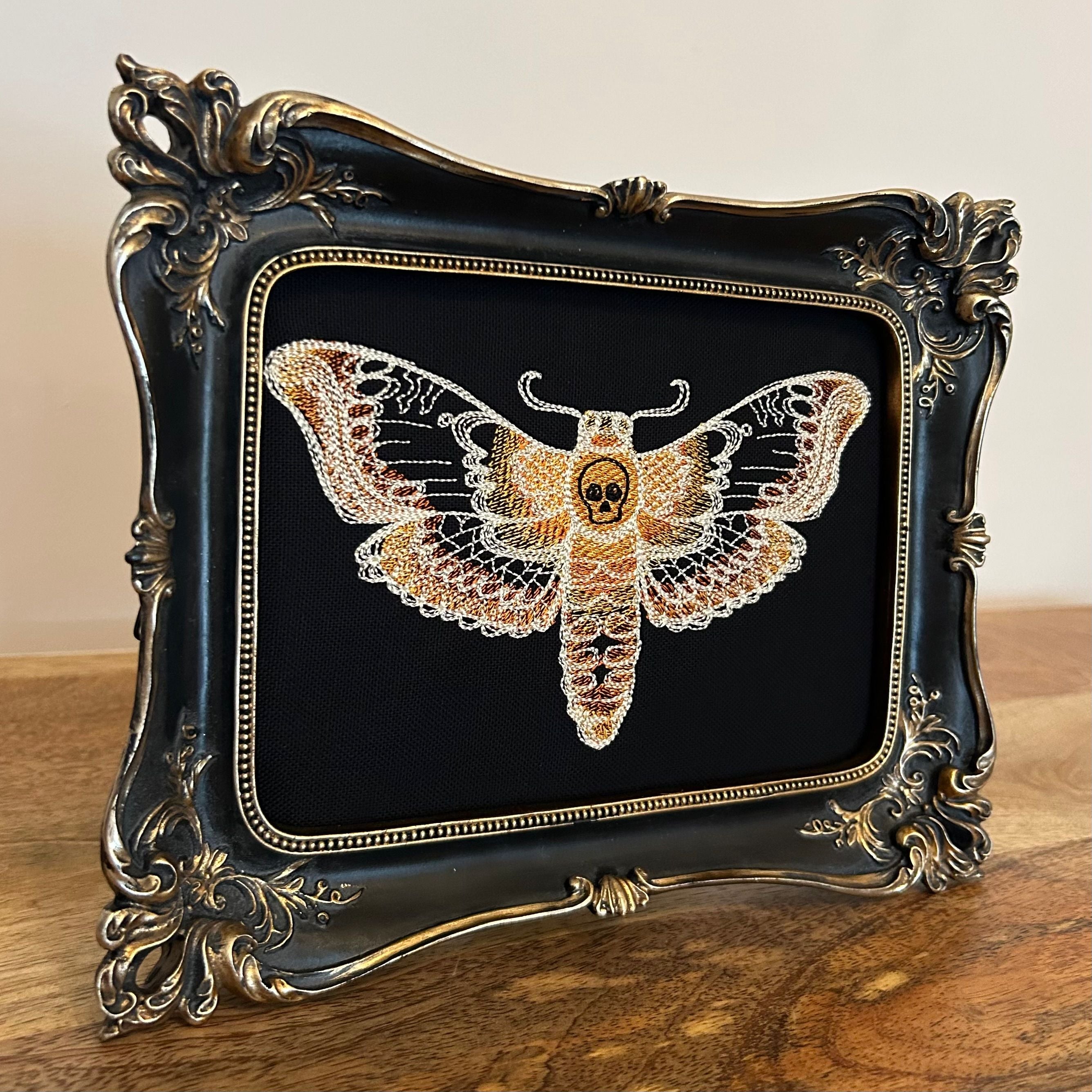 Death Head Moth lace embroidery art framed in a distressed gold and black vintage gothic picture frame.
