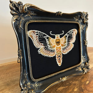 Death Head Moth lace embroidery art framed in a distressed gold and black vintage gothic picture frame.