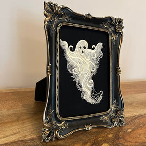 White lace Ghost embroidery art framed in a distressed gold and black vintage gothic picture frame.