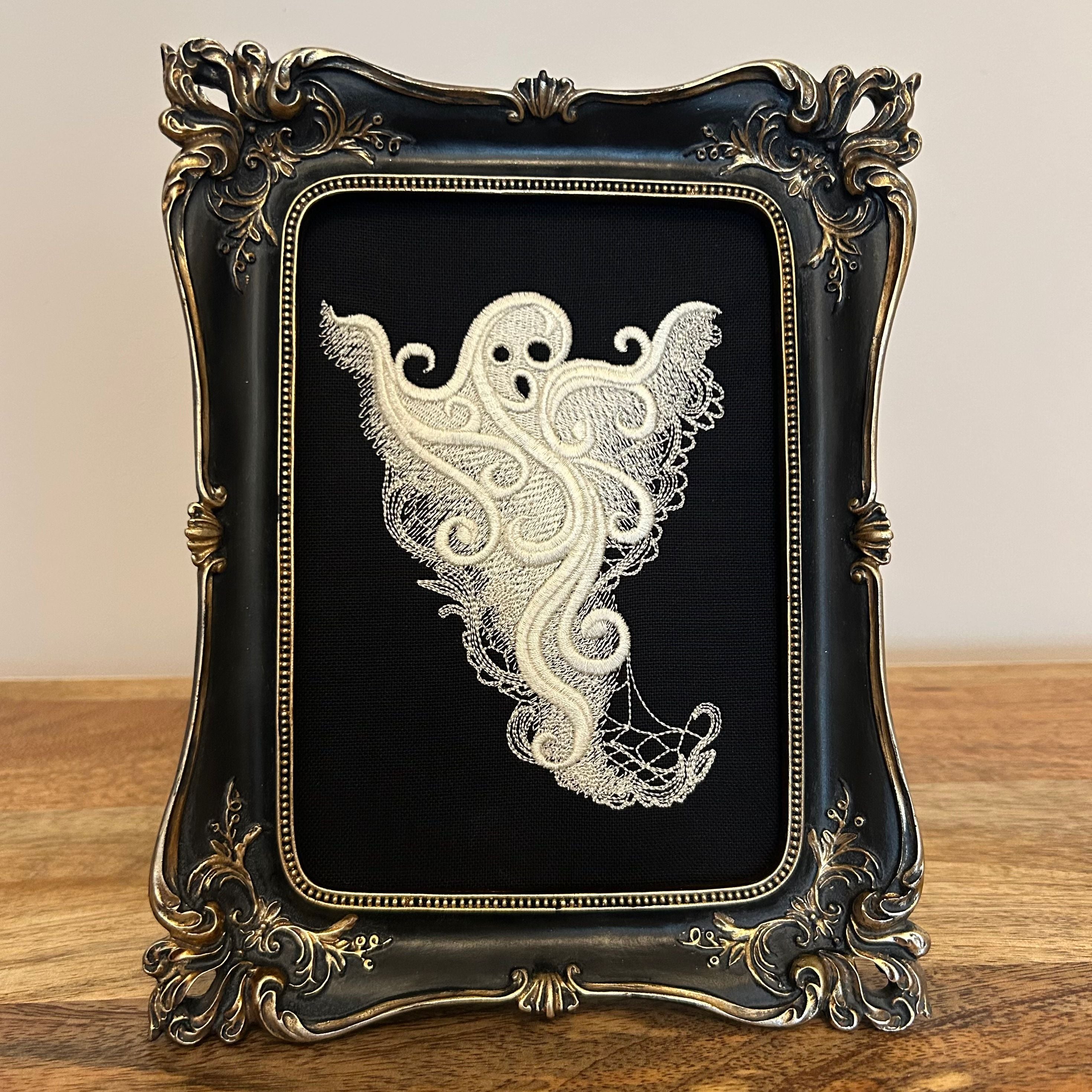White lace Ghost embroidery art framed in a distressed gold and black vintage gothic picture frame.